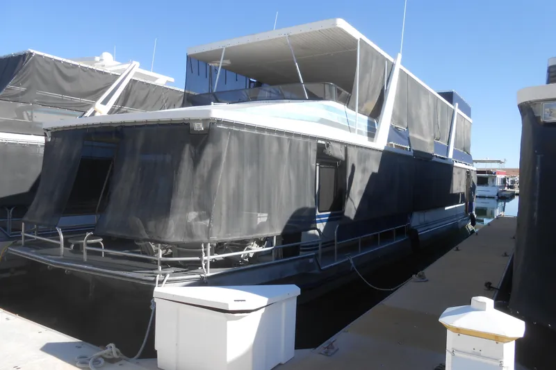 The Image of 1991 Stardust Cruisers 7516 houseboat docked at marina with covered upper deck. - 1