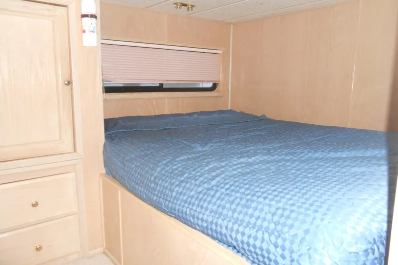 Slide: The Image of Cozy bedroom interior of 1991 Stardust Cruisers 7516 with blue bedding and wooden cabinetry. - 13
