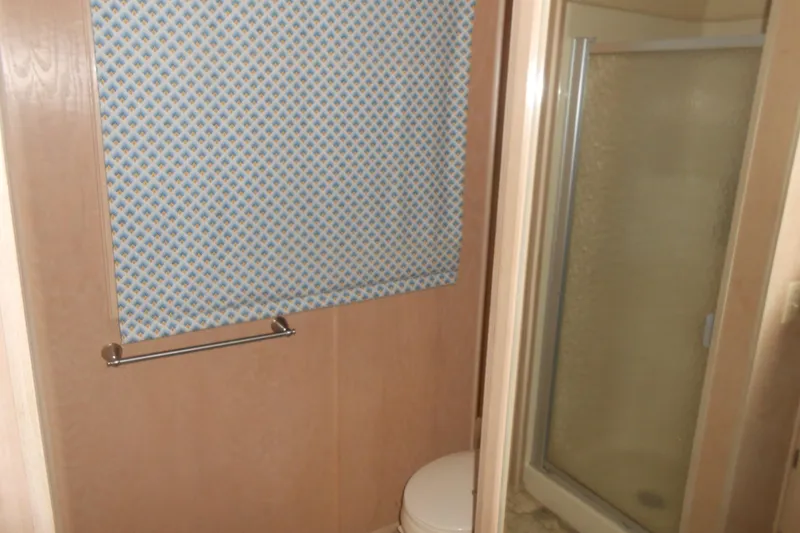 Slide: The Image of Bathroom interior of 1991 Stardust Cruisers 7516 with shower and patterned window covering. - 14