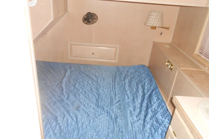 Slide: The Image of Interior of 1991 Stardust Cruisers 7516 with blue bedspread and wall-mounted lamp. - 16