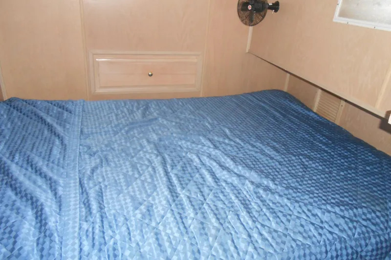 Slide: The Image of Interior of 1991 Stardust Cruisers 7516 with blue bedspread and wooden paneling. - 17