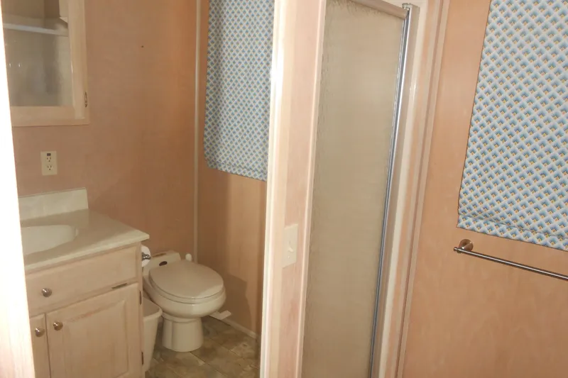 Slide: The Image of Bathroom interior of 1991 Stardust Cruisers 7516 with shower, toilet, and sink. - 18