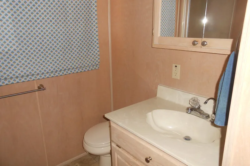Slide: The Image of Bathroom interior of 1991 Stardust Cruisers 7516 with sink, mirror, and patterned curtain. - 19
