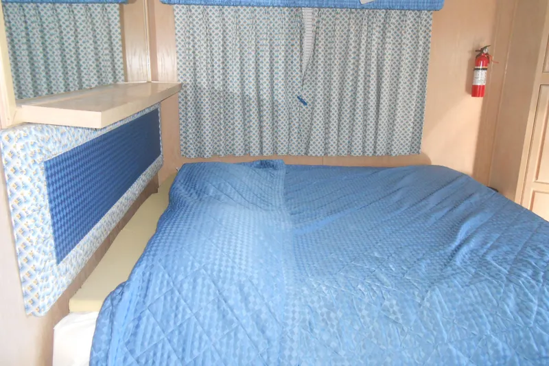 Slide: The Image of Interior of 1991 Stardust Cruisers 7516 with blue bedding and patterned curtains. - 20