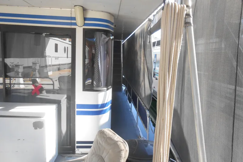 Slide: The Image of 1991 Stardust Cruisers 7516 houseboat with blue stripes and outdoor seating area. - 39