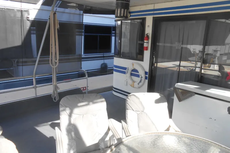 Slide: The Image of 1991 Stardust Cruisers 7516 houseboat deck with chairs, table, and life preserver. - 40