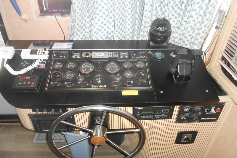 Slide: The Image of Control panel of a 1991 Stardust Cruisers 7516 houseboat with steering wheel and gauges. - 6