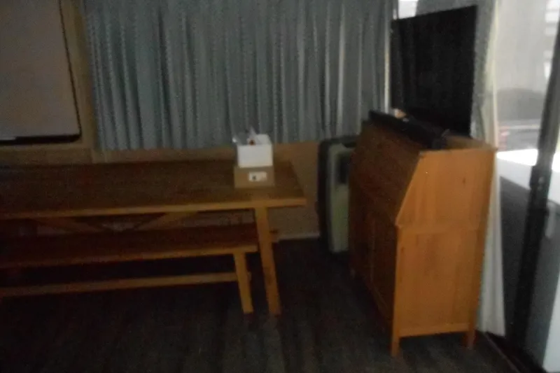 Slide: The Image of Interior of a 1991 Stardust Cruisers 7516 with wooden furniture and curtains. - 7