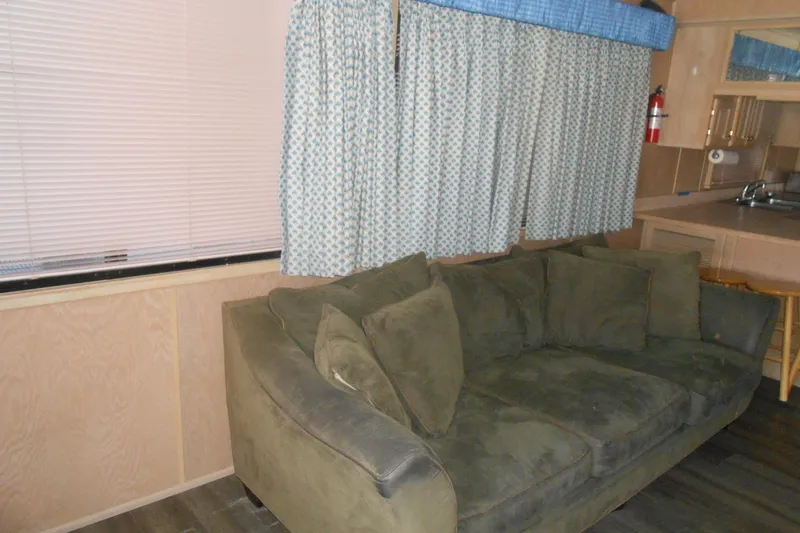 Slide: The Image of Interior of a 1991 Stardust Cruisers 7516 with green sofa and patterned curtains. - 8