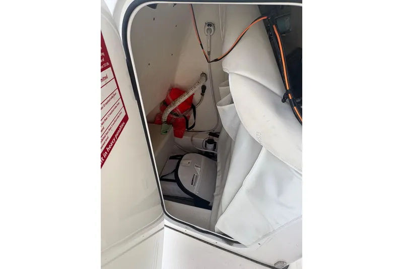 Slide: The Image of Storage compartment of 2021 Tidewater 198 CC Adventure boat, featuring safety equipment and wiring. - 8