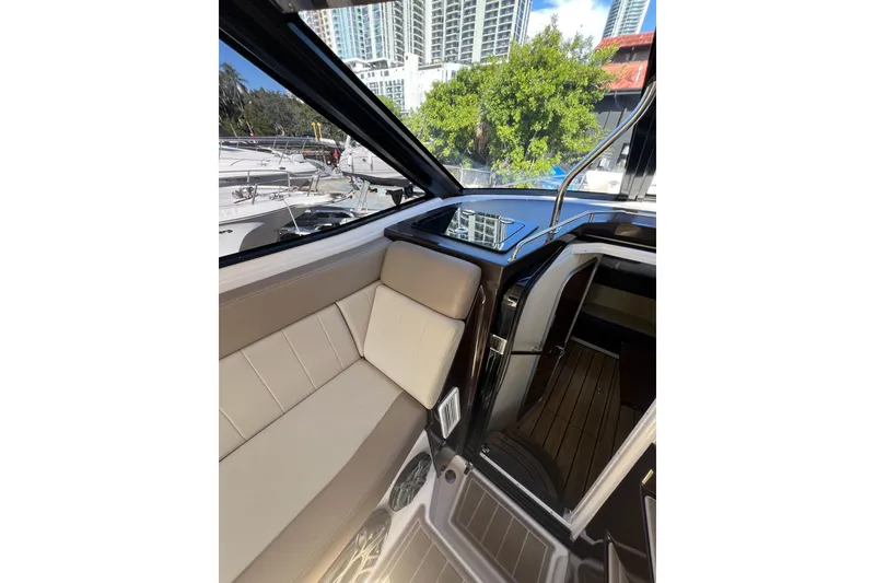 Slide: The Image of Interior of 2015 Regal 35 Sport Coupe yacht with beige seating and cityscape view. - 12