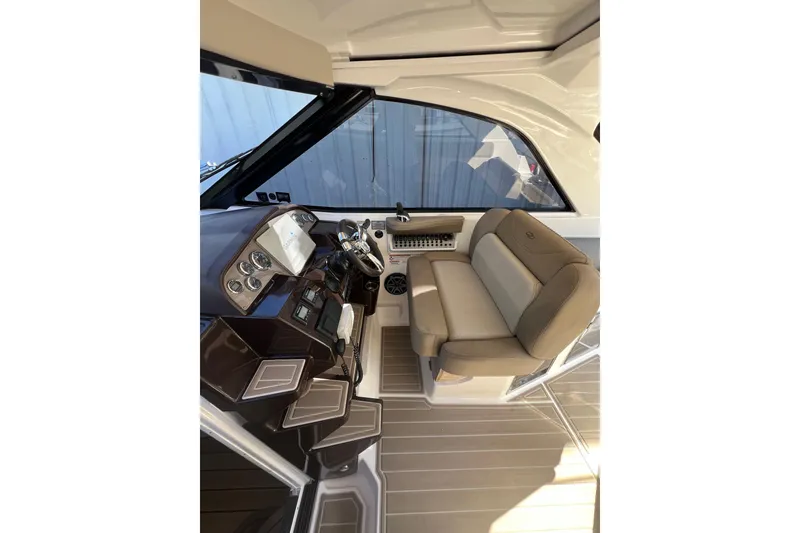 Slide: The Image of Interior of 2015 Regal 35 Sport Coupe, featuring helm and beige seating. - 13