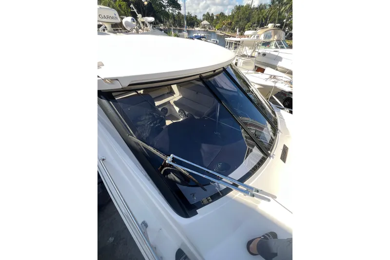 Slide: The Image of 2015 Regal 35 Sport Coupe boat with sleek windshield and marina background. - 30