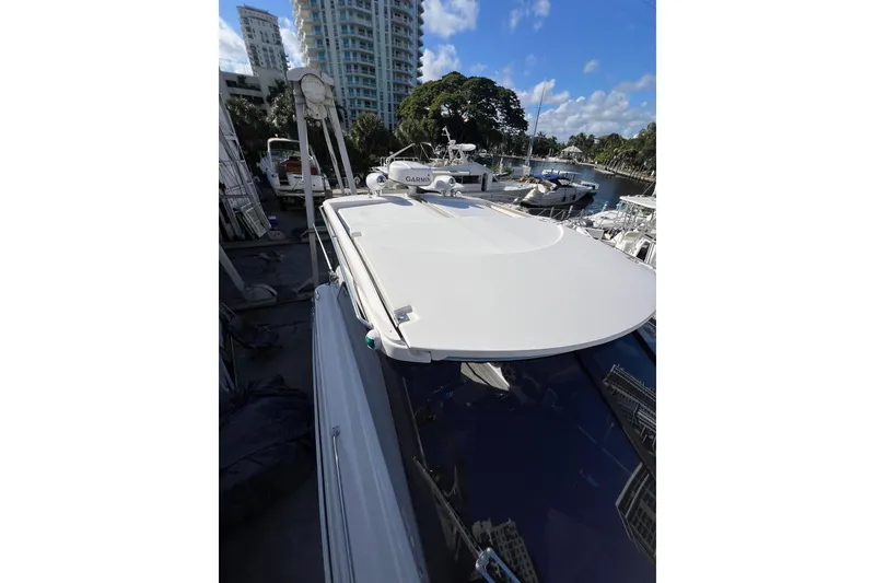 Slide: The Image of 2015 Regal 35 Sport Coupe yacht docked in marina, surrounded by buildings and trees. - 31