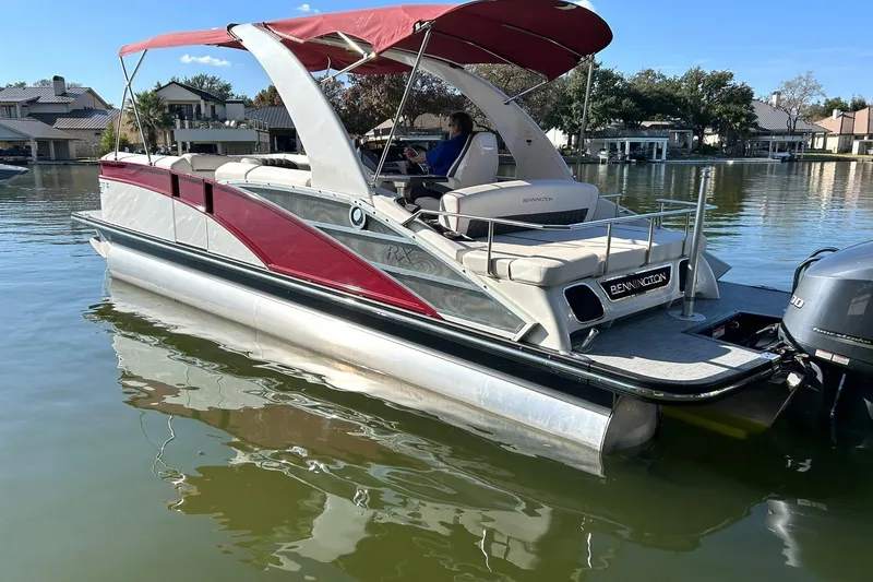 Slide: The Image of 2021 Bennington 25 RXSBA pontoon boat with red canopy on a calm lake. - 11