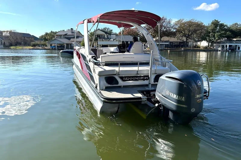 Slide: The Image of 2021 Bennington 25 RXSBA pontoon boat with Yamaha 300 engine on a calm lake. - 12