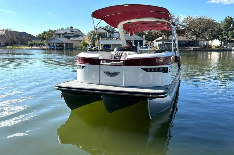 Slide: The Image of 2021 Bennington 25 RXSBA pontoon boat on a calm lake with red canopy. - 23