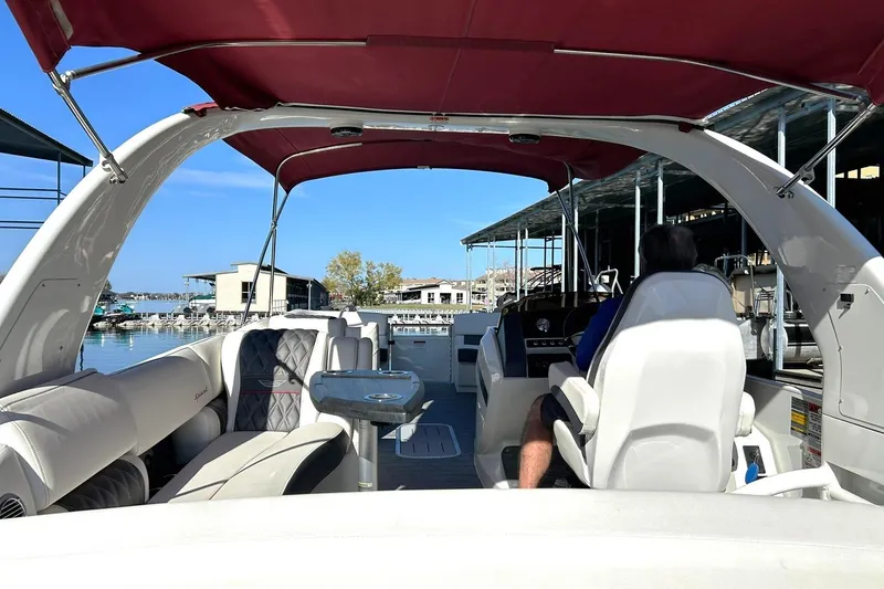 Slide: The Image of 2021 Bennington 25 RXSBA pontoon boat with red canopy, docked at marina. - 31