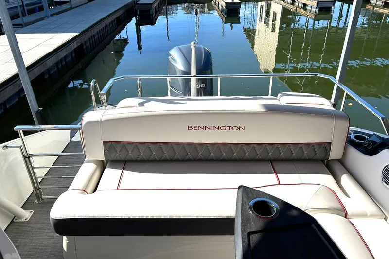 Slide: The Image of 2021 Bennington 25 RXSBA boat interior with luxurious seating at a marina. - 32