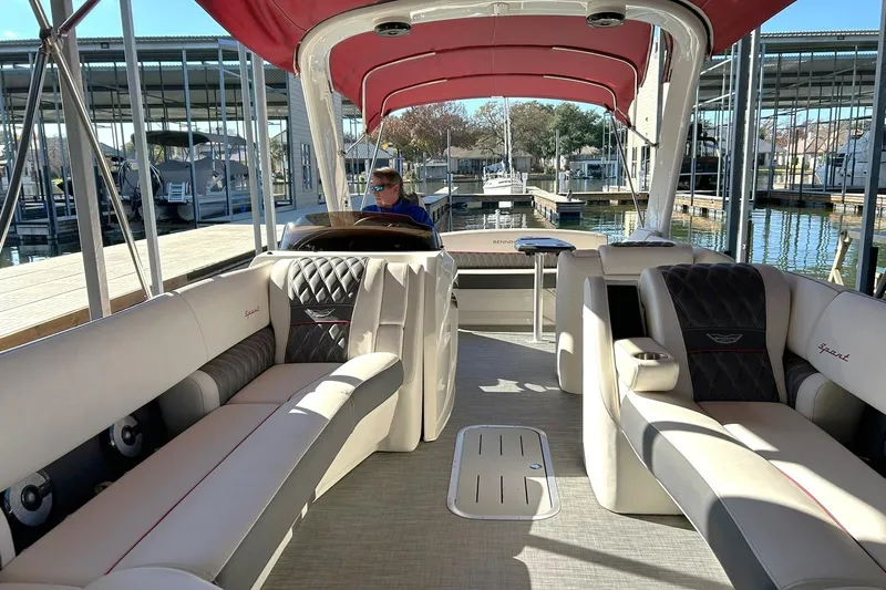 Slide: The Image of 2021 Bennington 25 RXSBA pontoon boat interior with luxurious seating and red canopy. - 4