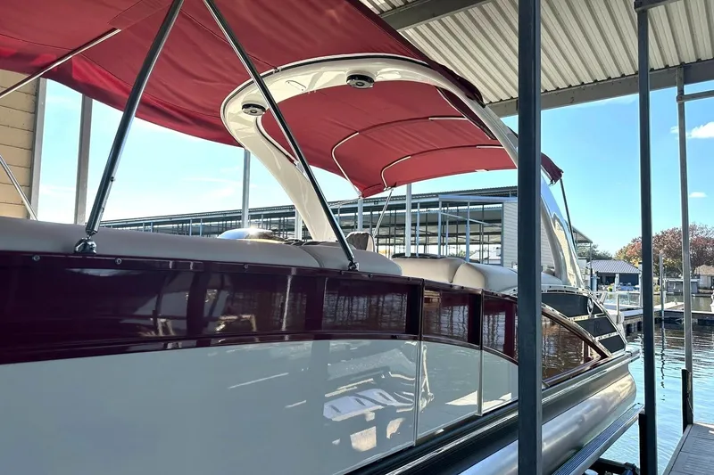 Slide: The Image of 2021 Bennington 25 RXSBA pontoon boat with red canopy docked at marina. - 57