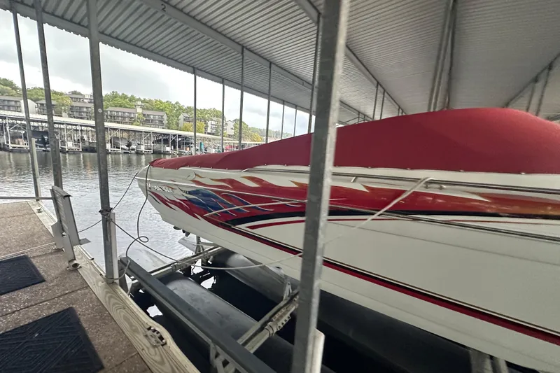 Slide: The Image of 2000 Formula 353 FASTech boat with vibrant red and white design in a marina. - 11