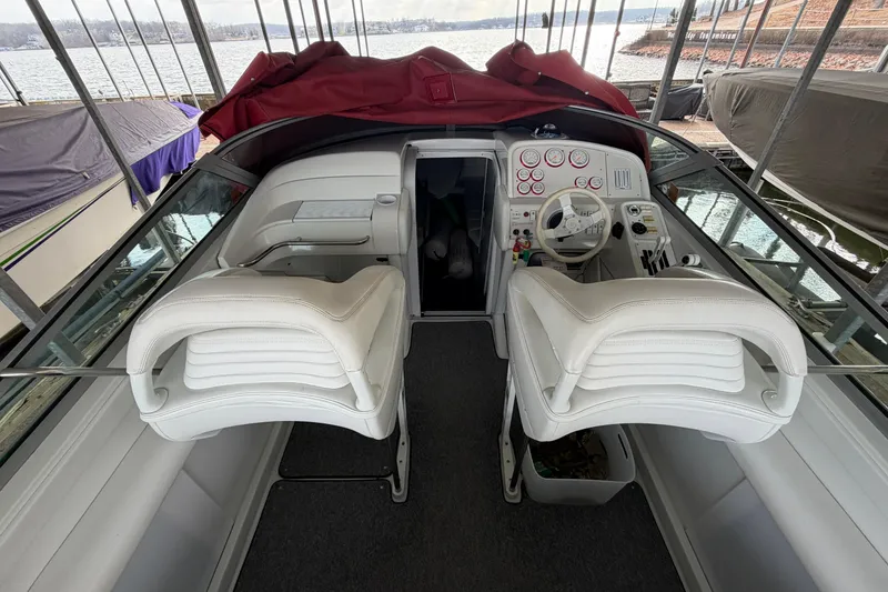 Slide: The Image of 2000 Formula 353 FASTech boat interior with white seating and control panel, docked by the water. - 13