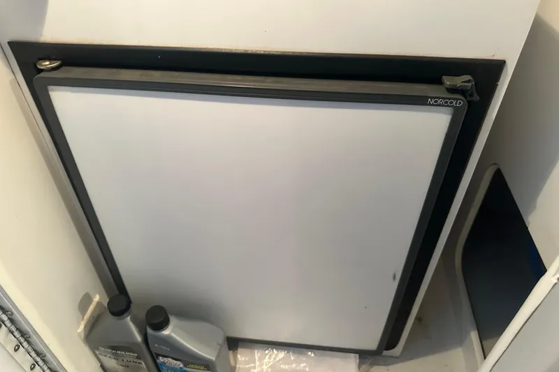 Slide: The Image of Norcold refrigerator in a 2000 Formula 353 FASTech boat, with engine oil containers nearby. - 28