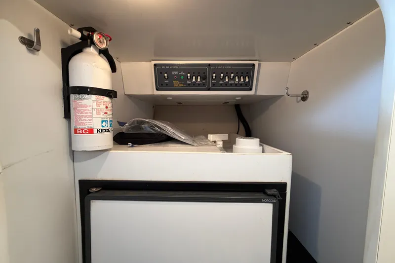 Slide: The Image of 2000 Formula 353 FASTech cabin with fire extinguisher, control panel, and Norcold refrigerator. - 29