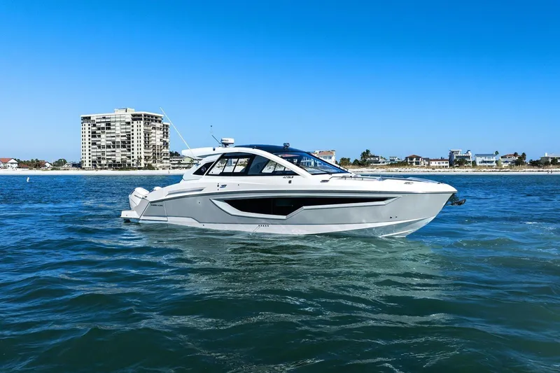 Slide: The Image of 2026 Cruisers Yachts 42 GLS OB on water, coastal buildings in background. - 2