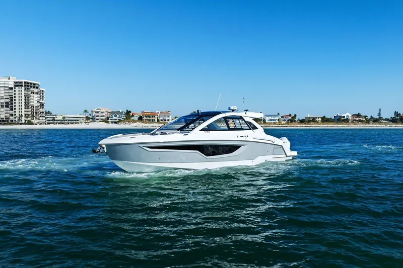 Slide: The Image of 2026 Cruisers Yachts 42 GLS OB on open water, coastal buildings in background. - 3