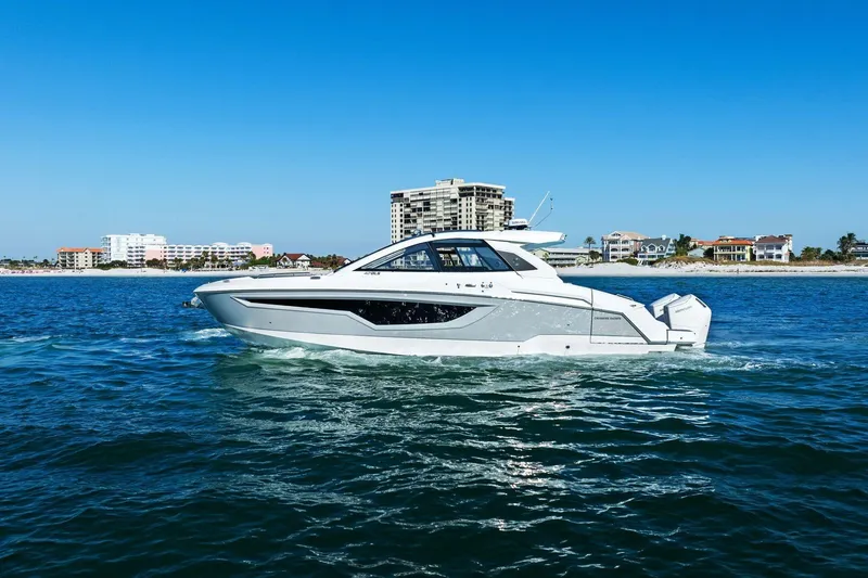 Slide: The Image of 2026 Cruisers Yachts 42 GLS OB on water with coastal buildings. - 4