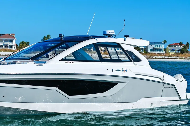 Slide: The Image of 2026 Cruisers Yachts 42 GLS OB on water near coastal homes. - 5