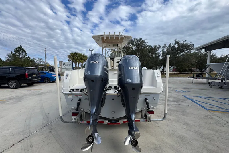 Slide: The Image of 2020 Sailfish 242 CC boat with dual Yamaha 150 engines in a parking lot. - 14