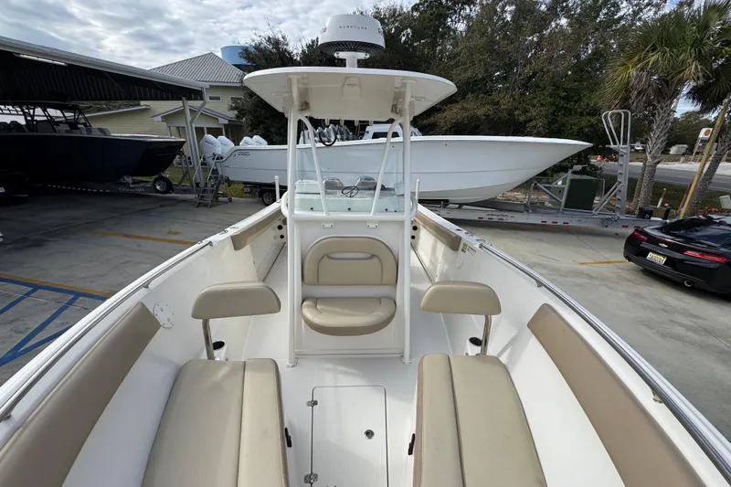 Slide: The Image of 2020 Sailfish 242 CC boat interior with seating, parked outdoors. - 23