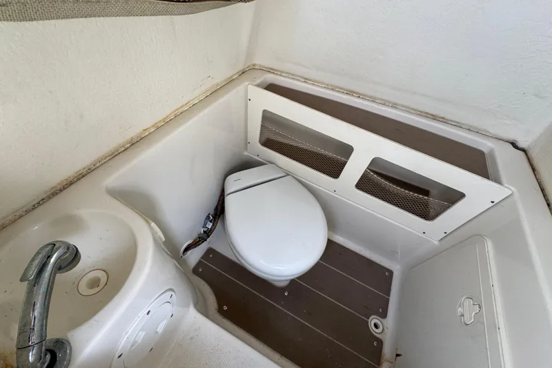Slide: The Image of 2020 Sailfish 242 CC boat interior with compact toilet and sink. - 27