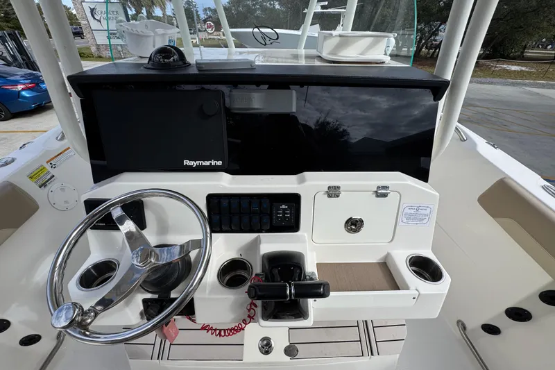 Slide: The Image of 2020 Sailfish 242 CC boat console with steering wheel and Raymarine display. - 32