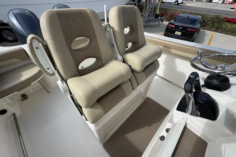 Slide: The Image of Dual captain's chairs on 2020 Sailfish 242 CC boat, featuring beige upholstery and steering console. - 35