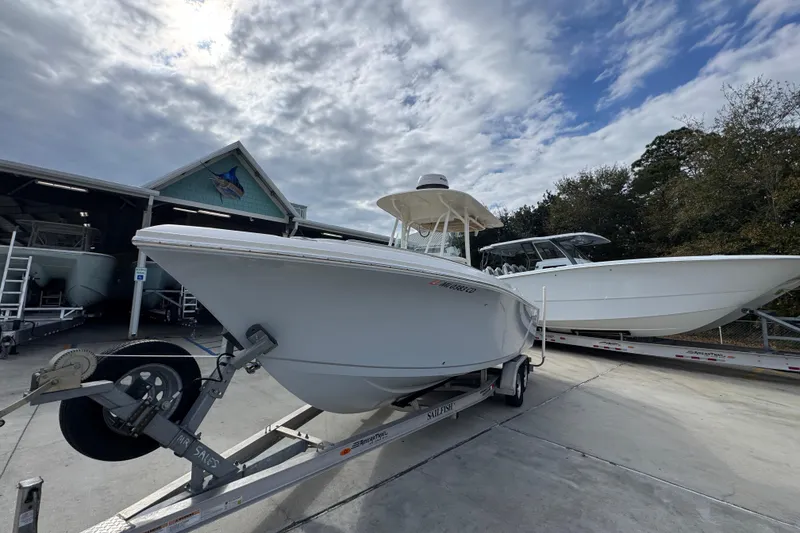 Slide: The Image of 2020 Sailfish 242 CC boat on trailer, parked outdoors under cloudy sky. - 4