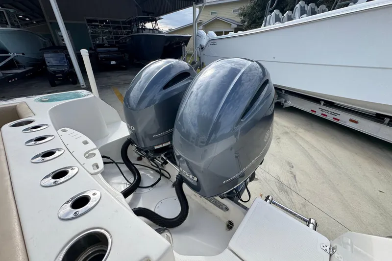 Slide: The Image of Twin outboard motors on a 2020 Sailfish 242 CC boat in a marina setting. - 40