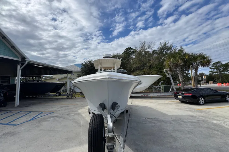 Slide: The Image of 2020 Sailfish 242 CC boat on trailer under cloudy sky, parked near buildings and trees. - 6