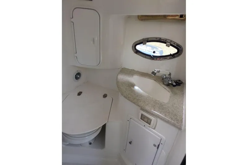 Slide: The Image of 2009 Fountain 38 Express Cruiser bathroom with sink, toilet, and porthole window. - 8