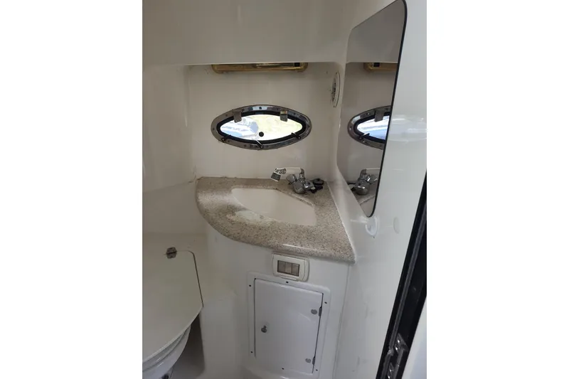 Slide: The Image of 2009 Fountain 38 Express Cruiser bathroom with sink, mirror, and porthole window. - 9