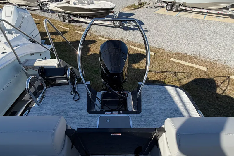 Slide: The Image of 2026 Bennington 22 MFB boat with outboard motor, parked on gravel lot. - 11