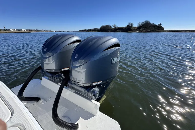 Slide: The Image of Twin Yamaha outboard engines on a 2022 Albemarle 25 Express boat in calm waters. - 15