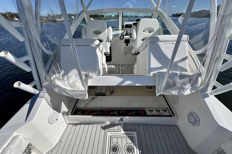 Slide: The Image of 2022 Albemarle 25 Express boat interior with seating and helm, docked on water. - 19