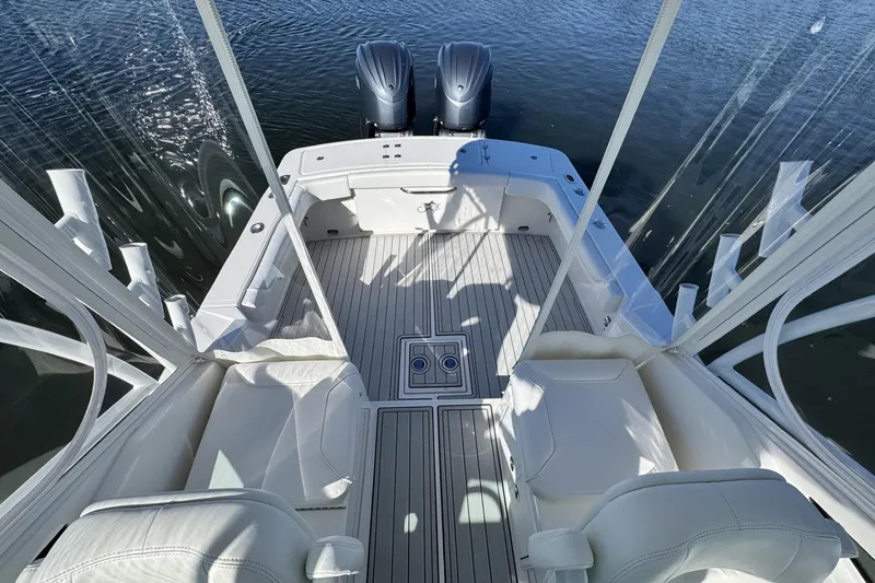 Slide: The Image of 2022 Albemarle 25 Express boat interior with twin engines, white seating, and sleek design. - 25