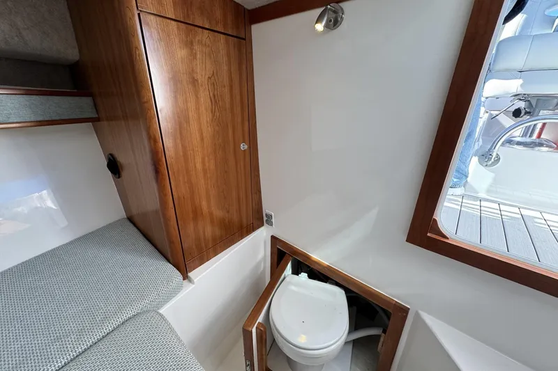 Slide: The Image of 2022 Albemarle 25 Express cabin interior with wooden cabinetry and compact marine toilet. - 36