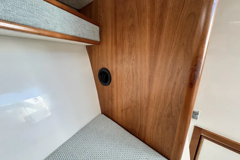 Slide: The Image of 2022 Albemarle 25 Express cabin interior with wood paneling and cushioned seating. - 39