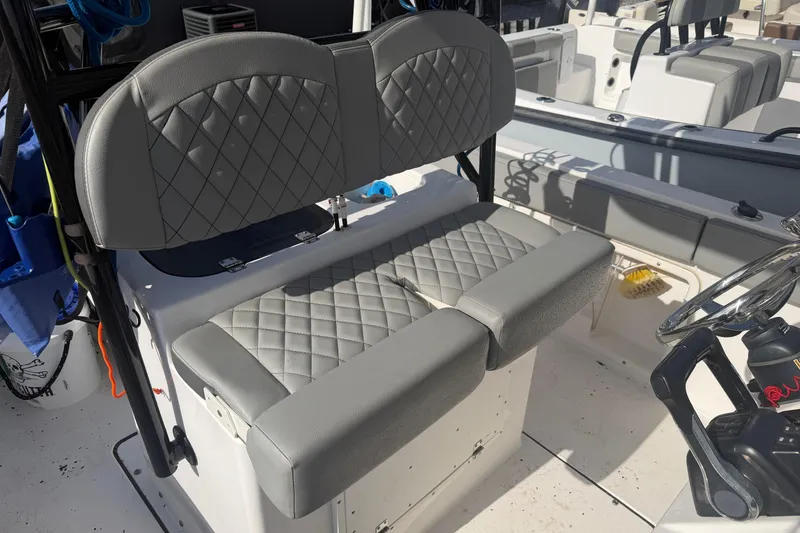 Slide: The Image of 2024 Clearwater 2800 boat with diamond-stitched gray seating and steering wheel. - 15